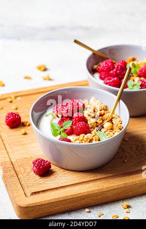 Muesli con lamponi e yogurt in una ciotola grigia. Concetto di cibo sano. Foto Stock