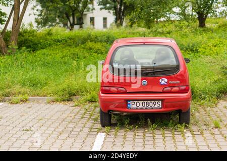 POZNAN, POLONIA - 12 agosto 2017: Fiat Seicento rossa parcheggiata in un parcheggio con erbacce verdi Foto Stock