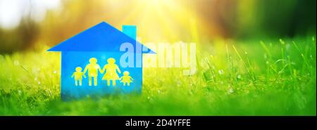 Casa di famiglia blu sull'erba verde in una mattina soleggiata. Foto Stock