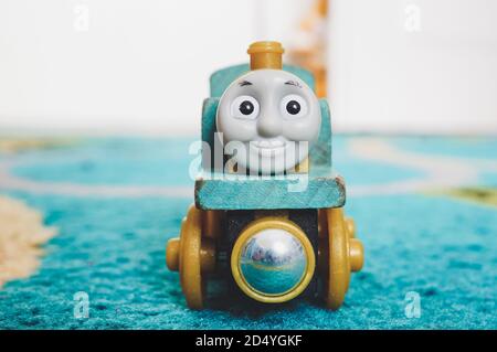 POZNAN, POLONIA - Feb 19, 2017: Locomotiva giocattolo in legno Thomas e amico su un tappeto blu a fuoco morbido Foto Stock