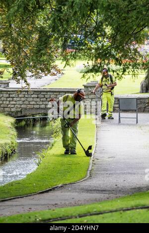 Lavoratori Cormac striping erba in Trenance Gardens a Newquay in Cornovaglia. Foto Stock