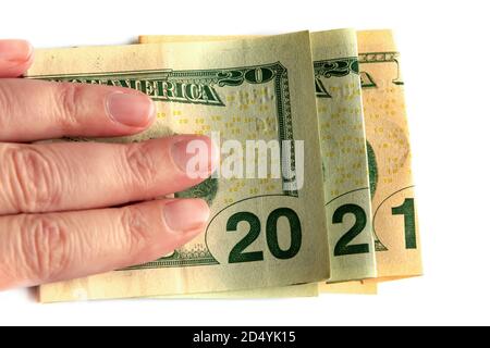 2021 scritto con banconote in dollari in una mano isolato su sfondo bianco, nuovo anno saluti denaro concetto Foto Stock