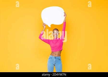 Sorridente bella donna afroamericana alzando vuoto bolla di parola isolato su colorato sfondo giallo studio Foto Stock