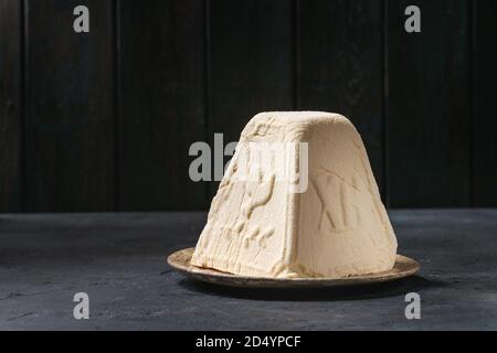 Tradizionale russo Pasqua cottage cheese dessert, Paskha ortodossa in piedi nella piastra di ceramica sulla texture scuro tavolo. Spazio di copia Foto Stock