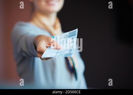 Primo piano di un'inriconoscibile assistente di volo femminile che consegna i biglietti al passeggero mentre si trova al banco del check-in in aeroporto, spazio fotocopie Foto Stock