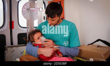 l'infermiera abbraccia un bambino e lo cura all'interno dell'ambulanza. Foto Stock