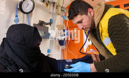 l'infermiera abbraccia un bambino e lo cura all'interno dell'ambulanza. Foto Stock