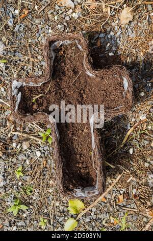 Piantatrice a forma di croce con rivestimento in plastica e terreno in un cimitero, County Kildare, Irlanda Foto Stock