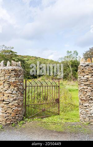 Porta di ferro aperta tra le colonne di pietra di un campo vicino a Old Head, Louisburgh, County Mayo, Irlanda Foto Stock