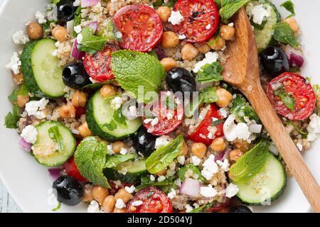 Pomodori vegetariani da insalata, cetrioli, ceci, olive, erbe, ricotta, vista dall'alto Foto Stock