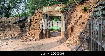 Tempio indù Prasat Krahom a Koh Ker. Paesaggio archeologico di Koh Ker, Cambogia nord-occidentale. Muschio sulla pietra mattoni arenaria laterite blocchi porta Foto Stock