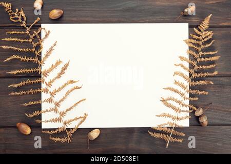 Carta bianca su tavola di legno e decorazione autunnale. Modello, Mock-up. Autunno sfondo. Vista dall'alto Foto Stock