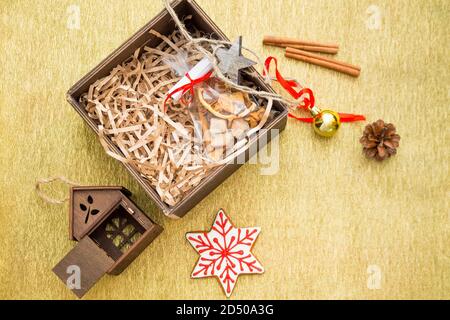 Allegro Natale flatlay con sfondo spazio copia dorata con regali, palle di Natale, giocattoli, canne di zucchero e spazio copia nero. Foto Stock