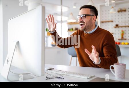Uomo che ha videoconferenza chiamata via computer. Lavorare in remoto per la gestione del team e del lavoro da casa Foto Stock