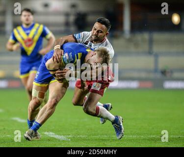 Matt Davies di Warrington Wolves fermato da Bevan francese di Guerrieri di Wigan Foto Stock