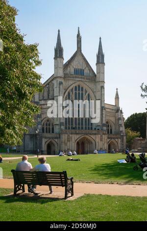 Panchina per coppie senior, vista in estate di una coppia senior seduta su una panchina nei terreni della Winchester Cathedral, Hampshire, Inghilterra, Regno Unito. Foto Stock