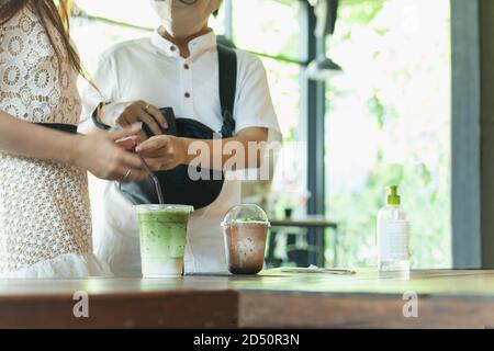 Nuovo normale piccola impresa freddo tè verde matchd e mocha ghiacciato in tazza di plastica sul tavolo nel caffè. Foto Stock