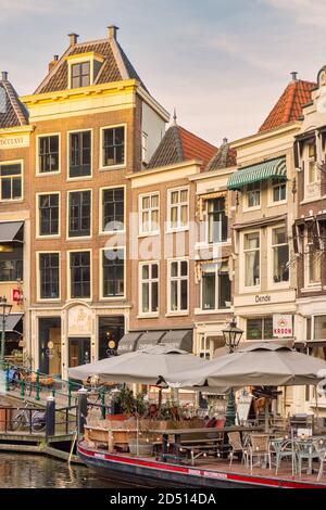 Leiden, Paesi Bassi - 16 gennaio 2020: Vista sul canale olandese Oude Rijn con terrazza barca, bar, ristoranti e negozi nel centro storico della città Foto Stock