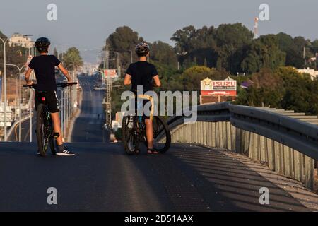 Israele, i bambini e le famiglie si godono le strade vuote per fare un giro in bicicletta durante Yom Kippur. Praticamente tutto il traffico motorizzato si ferma durante la bufale ebraica Foto Stock