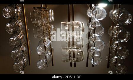 Tovame di birra in vetro che si tramandano dal soffitto di legno di un bar. Diversi tipi di tazze per diverse birre. Foto Stock