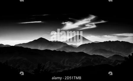 Iconico Monte Fuji avvolto in misty nuvole come e vecchio dipinto, visto dal Monte Takao in Giappone (bianco e nero) Foto Stock