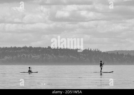 Un padre e un bambino paddlboard attraverso Puget Sound vicino Seattle Foto Stock