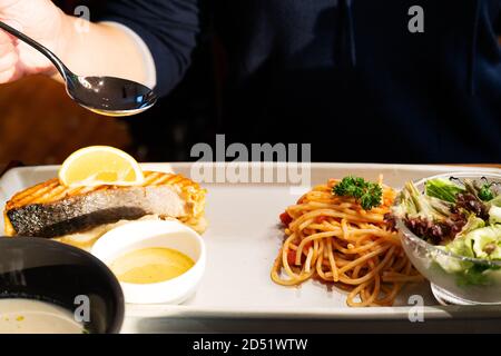 Spaghetti italiani con una gustosa bistecca di salmone alla griglia e purè patate dolci Foto Stock