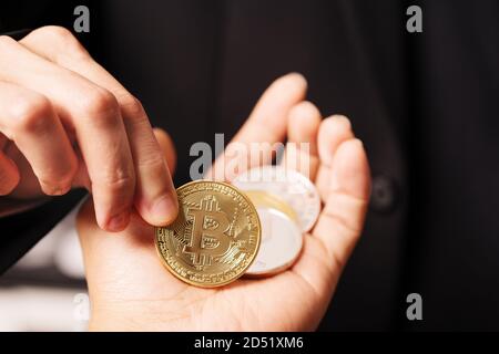 Cryptocurrency Bitcoin. Le donne ricoprono il cryptocurrency moneta sulla mano. Physical bitcoins moneta in oro Foto Stock