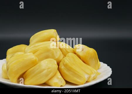 Jackfruit freschi fette su una piastra bianca. dolce jackfruit Giallo maturo. vegetariano vegano cibo crudo. Esotica frutta tropicali - isolato Foto Stock