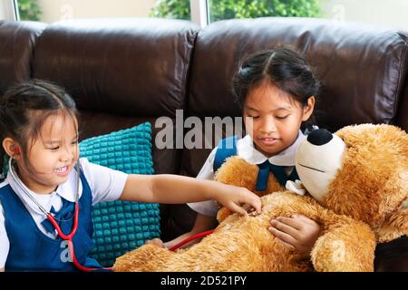 Due bambina sono sorridente e riproduzione medico con stetoscopio. Kid e health care concetto. Foto Stock