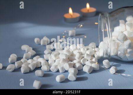 marshmallows in un vaso di vetro su sfondo azzurro Foto Stock