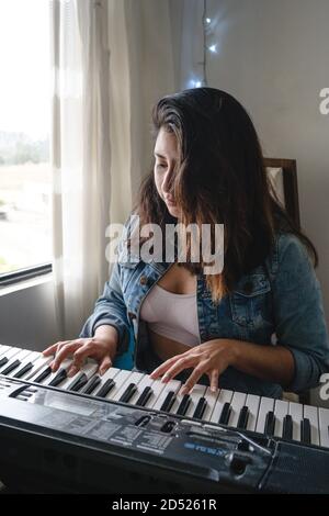 Ragazza che suona piano durante il blocco Foto Stock