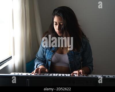 Ragazza che suona piano durante il blocco Foto Stock