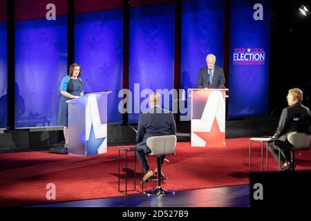 Austin TX USA, 9 ottobre 2020: Lo sfidante democratico MJ Hegar (l) risponde a una domanda mentre discute il senatore statunitense John Cornyn a tre anni. Il veterano di guerra decorato di 44 anni tenta di ssede Cornyn, uno stallo repubblicano. I moderatori Grimer Jeffers Jr. (L) e Robert Hadlock si siedono in primo piano. Foto Stock