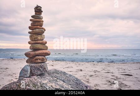 Piramide di pietra su una spiaggia, zen, armonia e concetto di equilibrio, tonalità di colore applicato. Foto Stock