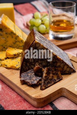 Formaggio irlandese marrone, formaggio blu e un bicchiere di degustazione di un piatto unico whisky irlandese da vicino Foto Stock