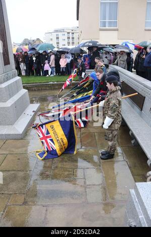 Troon Remembrance Parade, South Ayrshire, Scozia , Regno Unito. Nonostante la pioggia battente, i gruppi giovanili, i membri della forza armata, i veterani, i politici, i funzionari del consiglio locale hanno marciato al centaph commemorativo di guerra a Troon per pagare i loro rispetti e deporre le corone. Il giovane abbassa i colori all'inizio dei due minuti di scorrimento Foto Stock