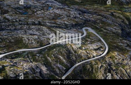Guida in auto su una strada stretta e tortuosa passo di montagna giù sotto in una giornata di autunno luminoso, Norvegia Dalsnibba Foto Stock
