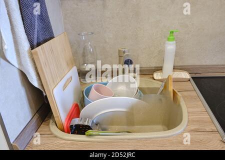 Lavandino della cucina riempito alla parte superiore con piatti sporchi non lavati prima e dopo il lavaggio, concetto Foto Stock
