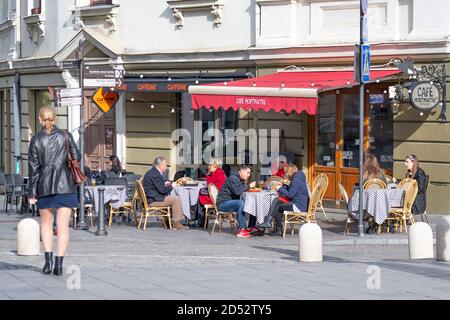 Caffetteria all'aperto, bar o ristorante con i clienti ai tavoli durante l'epidemia di Covid o Coronavirus Foto Stock