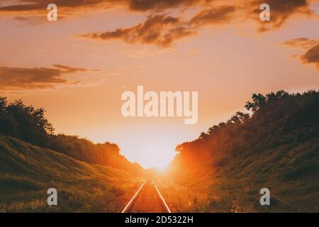 Ferrovia in spettacolare Sunset Backlight. Vista panoramica della ferrovia che va subito sotto la luce del sole. Trasporto e viaggio Railroad Concept Foto Stock