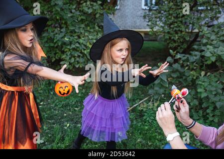 I bambini piccoli trick o trattare. Due piccole streghe spaventano i vicini su Halloween Foto Stock