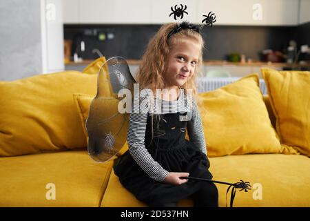 Bambina simpatica vestita in costume canivale di strega. Halloween vacanza durante il periodo di quarantena Foto Stock