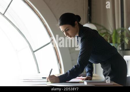 Giovane donna d'affari indiana lavora con i documenti in ufficio Foto Stock