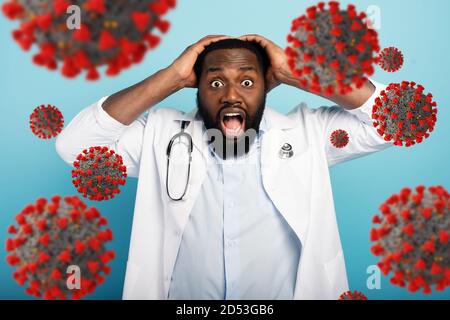 Il medico ha paura a causa di un attacco di virus codiv19. Sfondo ciano Foto Stock