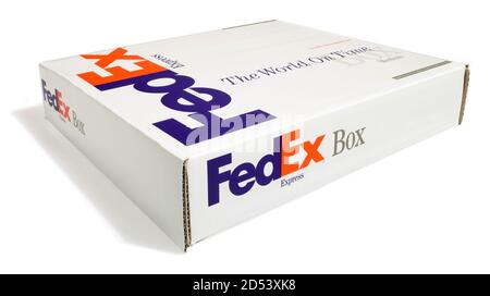 Una scatola FedEx fotografata su uno sfondo bianco su un angolo Foto Stock