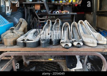 Scarpe da donna con tacco alto indossate in mostra in una riparazione scarpe negozio Foto Stock