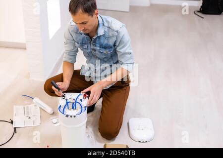 L'impianto idraulico installa un filtro dell'acqua. Filtro dell'acqua. Foto Stock