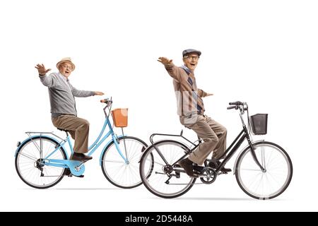 Due anziani che cavalcano biciclette con braccia aperte isolate su sfondo bianco Foto Stock