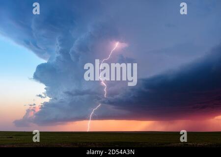 Fulmine colpire in una nuvola di tempesta di supercelle al tramonto vicino Briggsdale, Colorado Foto Stock